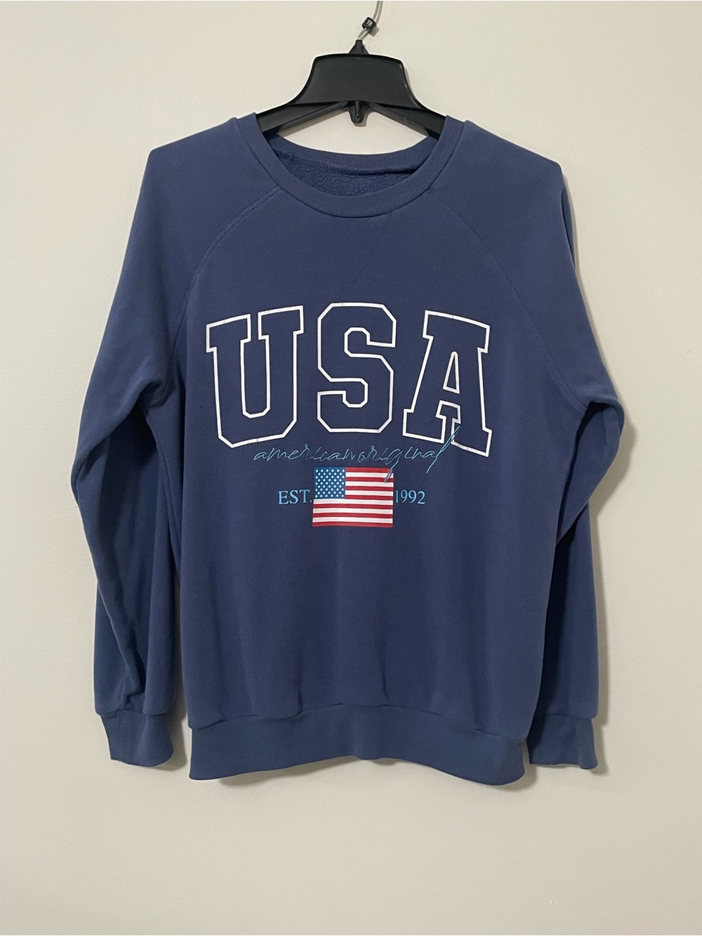 Navy blue crewneck sweatshirt with white USA text, American flag, and EST 1992
